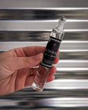 Perfume shown in front of metal background.
