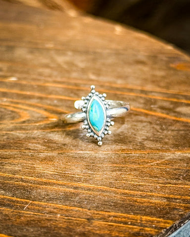Turquoise Ring displayed on wooden table.
