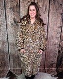 Person wearing a leopard print blanket hoodie against a wooden background