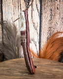 Brown leather bag with a decorative element on a wooden surface