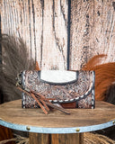wallet with floral embossing on a wooden surface with a rustic background