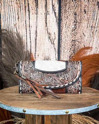 wallet with floral embossing on a wooden surface with a rustic background