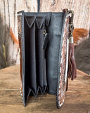 Inside of leather wallet with intricate brown designs on a wooden surface