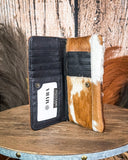 Wallet with cowhide leather trim on a wooden surface