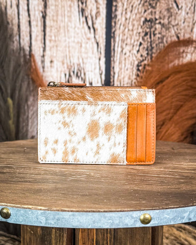 Card holder with cowhide pattern on a wooden surface