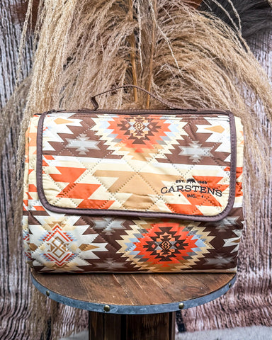 Patterned picnic blanket on a wooden stand with a rustic background