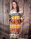 Woman wearing a patterned hooded blanket against a wooden background