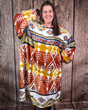 Woman wearing a patterned hooded blanket against a wooden background