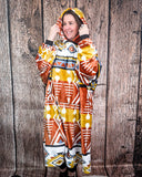 Person wearing a colorful patterned blanket hoodie against a wooden background