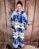 Person wearing a blue and white patterned blanket hoodie against a wooden background