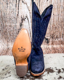 Navy blue cowboy boots with tan insole on a textured surface