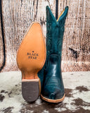 Teal cowboy boots with 'Black Star' branding on a rustic wooden background