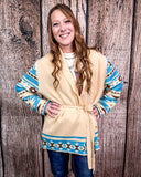 Woman wearing a patterned cardigan against a wooden background