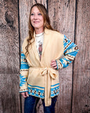 Woman wearing a patterned cardigan against a wooden background