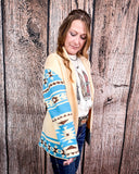 Woman wearing a patterned cardigan over a graphic t-shirt against a wooden background