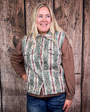 Woman wearing a patterned vest over a brown shirt against a wooden background