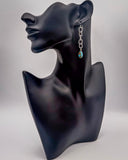 Earring on a black mannequin bust with a gray background