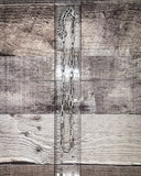 Metal chain on a wooden surface with a ruler for scale