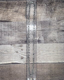 Long silver chain on a wooden surface with a ruler for scale