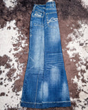 Pair of blue jeans on a textured brown and white surface