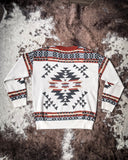 Lean On Me Knit Sweater displayed on cowhide.
