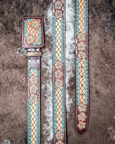 Decorative leather belt with floral patterns on a textured surface