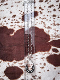 Silver horseshoe teardrop pendant necklace with Western beading shown on ruler for scale