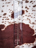 Western steer head necklace displayed on a ruler