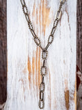 Gold toned Y necklace on a wooden background