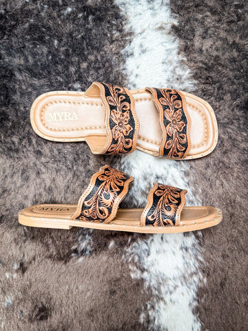 Side and top view of Myra brand leather sandals with black and tan floral carving details.