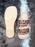 Top and sole view of tan leather sandals with floral tooled straps and non-slip rubber sole.