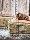 Platform sandal with ruler measurement showing 2.75-inch woven jute wedge heel on fur background.