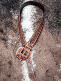 Brown floral tooled western belt styled in loop with matching engraved buckle.