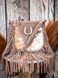 Front of western suede bag with cowhide panel, fringe details, and braided accents