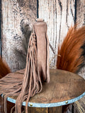 Side view of brown suede crossbody bag with long fringe tassels