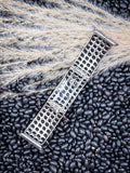 Studded silver Apple Watch band with domed design on black beans and wheat grass