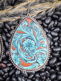 Detailed close-up of turquoise and rust leather floral earring on rustic bean and wheat setting