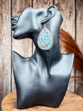 Teardrop tooled leather earring with turquoise and rust floral pattern displayed on black mannequin