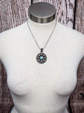 Silver western concho-style necklace with turquoise center pendant displayed on white mannequin
