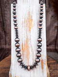 Southwestern oxidized bead necklace with brushed copper accents on rustic wood display.