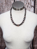 Classic copper and silver beaded faux Navajo pearl necklace displayed on mannequin bust.
