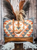 Weekender bag with shoulder strap displayed on a wood background