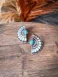 Earrings shown on wood with decorative grass in the background