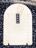 stud earring on small ruler, beans, and wheat