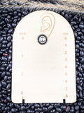 stud earring on small ruler, beans, and wheat