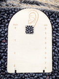 stud earring on small ruler, beans, and wheat