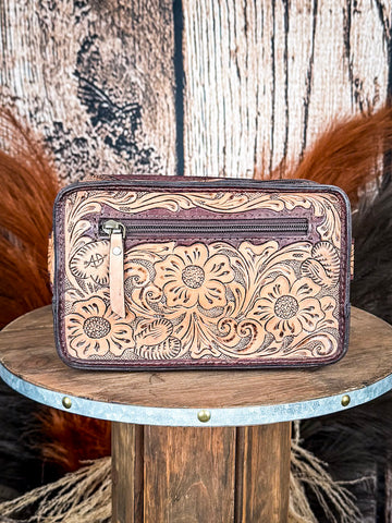 fanny pack on wood table, feathers in background, wood backdrop
