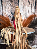 side of bag on wood table, feathers and wheat in background, wood backdrop