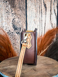 side of shoulder bag on wood table, feathers in background, wood backdrop