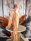 side pf bag on wood table, feathers and wheat in background, wood backdrop